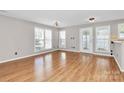 A well-lit and spacious living room features many windows for natural light and wood flooring at 2045 Flushing Ct, Charlotte, NC 28215