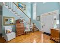 Inviting foyer with a staircase, light blue walls, hardwood floors, and decorative furnishings at 21216 Norman Shores Dr, Cornelius, NC 28031