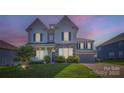 Charming two-story home at dusk featuring stone accents, gray siding, and a well-manicured lawn at 2322 Tessa Trce, Clover, SC 29710