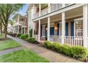 Row of brick townhomes with inviting front porches and blue shutters, complemented by manicured lawns and sidewalks at 239 N Faulkner Way, Davidson, NC 28036