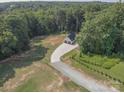 Aerial view of a property featuring a long driveway to a home, surrounded by lush trees at 2676 Will Schronce Rd, Iron Station, NC 28080