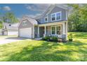 Beautiful home with a covered porch, an attached garage, and a well-manicured lawn at 2902 Oakdale Rd, Charlotte, NC 28216