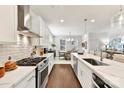 Well-lit kitchen has stainless steel appliances, white cabinets, subway tile backsplash, and an island with seating at 330 Armour St # 46, Davidson, NC 28036
