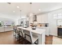 Modern kitchen with stainless steel appliances, white cabinets, and a center island with seating overlooks the living area at 330 Armour St # 46, Davidson, NC 28036