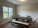 This Dining Room features neutral walls and carpet, and a window with backyard views at 348 Ox Bow Cir, Mount Holly, NC 28120
