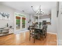 Bright dining area with hardwood floors, French doors, and a modern chandelier at 3915 Planters Watch Dr, Charlotte, NC 28278