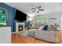 Cozy living room featuring a fireplace, large TV, and comfortable sectional sofa at 3915 Planters Watch Dr, Charlotte, NC 28278