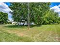 Single-story home with covered front porch surrounded by a large, mature tree on a grassy lot at 5785 Nc 150 E Hwy, Denver, NC 28037