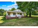 Quaint home with brick foundation, covered porch supported by white columns, and manicured front lawn at 5785 Nc 150 E Hwy, Denver, NC 28037