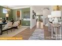 Beautiful entryway with an elegant dining room, wooden floors, and neutral walls that leads to the stairs at 6443 Honor Ave, Midland, NC 28107