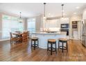 Bright kitchen with white cabinets, stainless steel appliances, and a breakfast bar with seating at 7040 Edenderry Dr, Charlotte, NC 28270