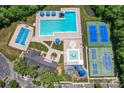 Aerial view of community pool, tennis courts, and playground with mature trees surrounding property at 9639 Ravenscroft Nw Ln, Concord, NC 28027