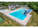 Aerial view of the community pool with waterslides, recreational pool, tennis courts, and lots of lounge chairs at 9639 Ravenscroft Nw Ln, Concord, NC 28027