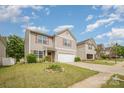 Charming two-story home featuring beige siding, red shutters, a well-manicured lawn, and an attached one car garage at 9718 Eagle Feathers Dr, Charlotte, NC 28214