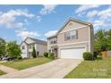 Beautiful two-story home with beige siding, red shutters, well-maintained lawn and driveway leading to an attached one-car garage at 9718 Eagle Feathers Dr, Charlotte, NC 28214