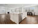 Open-concept kitchen boasts a large island, stainless steel dishwasher, and seamless flow into the living area at 9952 Manor Vista Trl, Kannapolis, NC 28027