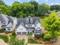 Beautiful home with a stone and white siding facade, dormer windows, a two-car garage, and mature landscaping at 1012 N Sharon Amity Rd, Charlotte, NC 28211