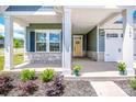 Inviting front porch with stone accents, offers a cozy entrance to the home, and manicured garden beds at 105 Chase View Ln, Troutman, NC 28166