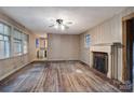 Spacious living room with hardwood floors, a fireplace, and abundant natural light from multiple windows at 109 N Belvedere Ave, Gastonia, NC 28054