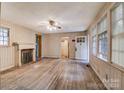 Cozy living room featuring a fireplace, hardwood floors, and a doorway leading to a room with natural light at 109 N Belvedere Ave, Gastonia, NC 28054