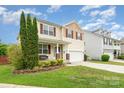 Beautiful two-story home boasts a welcoming front porch, and a well-maintained lawn at 1105 Bottle Brush Ln, Harrisburg, NC 28075