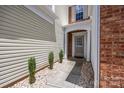 Inviting entrance with manicured shrubs, a walkway, and brick accents at 12407 Crowley Ct, Charlotte, NC 28277