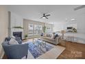 Bright living room with fireplace, ceiling fan, and views from three large windows at 12407 Crowley Ct, Charlotte, NC 28277