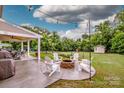 Inviting backyard with a cozy fire pit, seating area, and covered patio for outdoor gatherings at 130 Bay Laurel Dr, Mooresville, NC 28115