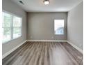 Inviting living room featuring sleek flooring, neutral paint, and natural light from two bright windows at 15003 Boudins Ln, Charlotte, NC 28278