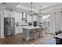 Modern white kitchen featuring an island with counter seating, stainless steel appliances, and pendant lighting at 1634 Dresden Dr, Rock Hill, SC 29732