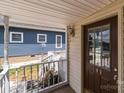 Covered porch with a view of the neighborhood; the front door has a window and the house number 165 at 165 Cardinal Dr # 615, New London, NC 27371