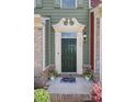 Elegant entryway with a dark green door, decorative molding, stylish lighting, and a welcoming floral rug at 1809 Evergreen Dr, Charlotte, NC 28208