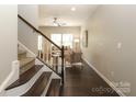 Inviting living room featuring hardwood floors, a ceiling fan, and staircase leading to the upper level at 1809 Evergreen Dr, Charlotte, NC 28208