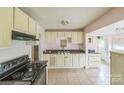 Spacious kitchen featuring tile floors, cream colored cabinets and black appliances at 1908 5Th St, Statesville, NC 28677