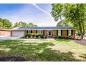 Beautiful brick home with a well-manicured lawn, shrubs, and a two-car garage on a sunny day at 195 Brookfield Cir, Mooresville, NC 28115