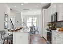 Bright kitchen with wood floors, white cabinets, marble counters and modern stainless steel appliances at 2009 Clarksdale Dr # 39, Charlotte, NC 28206