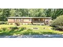 Home exterior with a cozy front porch and a well-manicured lawn with mature landscaping at 217 Eighth Ave, New London, NC 28127