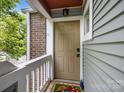 Inviting condo entrance featuring a covered porch and stylish front door at 2502 Cranbrook Ln # 8, Charlotte, NC 28207