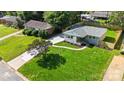 Aerial view showcases a landscaped lawn, a paved driveway, and mature trees surrounding the property at 4042 Uppergate Ln, Charlotte, NC 28215