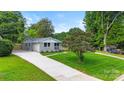 A charming house with a long driveway and a manicured lawn, enhanced by mature trees at 4042 Uppergate Ln, Charlotte, NC 28215