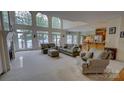 Bright living room with floor-to-ceiling windows offering stunning waterfront views and a cozy fireplace at 495 Bay Harbour Rd, Mooresville, NC 28117