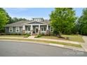 Beautiful one-story home with a charming front porch, a vibrant green lawn, and mature trees at 508 Flour Mill Ct, Fort Mill, SC 29715