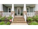 Welcoming front porch with brick steps, white railings, and lush landscaping leading to the front door at 508 Flour Mill Ct, Fort Mill, SC 29715