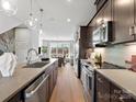 Modern kitchen with stainless steel appliances, an island sink, and a view of the open living space at 5512 Swaling St, Charlotte, NC 28217