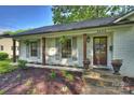 Inviting front entrance featuring gray shutters, dark wood columns, and stylish landscaping at 6624 Lancer Dr, Charlotte, NC 28226