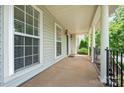 Spacious front porch with classic columns and iron railing, offering a welcoming entrance to the home at 6948 Church Wood Ln, Huntersville, NC 28078