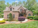 Beautiful brick home featuring a meticulously landscaped front yard and inviting curb appeal at 8216 Malibu Pointe Ln, Denver, NC 28037