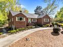 Inviting brick home showcasing a well-manicured lawn, garden beds, and a welcoming front entrance at 961 Confederate Ave, Salisbury, NC 28144