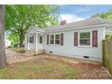 Cozy home with a covered front porch, symmetrical windows, and updated color palette at 104 Willetta Dr, Charlotte, NC 28217