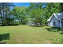 Spacious yard with mature trees; detached building offering versatile outdoor living and recreational opportunities at 108 Stockton St, Shelby, NC 28150